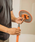 Person assembling Radius360 Round Sanding Tool With Interchangeable Center Hub 9 Inch, showing round pad and handle attachment.