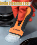 Razor Blade Scraper Tool Set 2 Pack With 80 Replacement Blades, orange and black, cleaning soapy residue on stovetop.