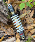 Rear Shock For Dirty Pit Bike With Adjustable Rebound And Dual Spring Options 250lb Or 350lb, easy install, forest background