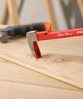 Cat's Paw Nail Puller Set Three Piece Pry Bar Kit Includes 8 Inch 10 Inch And 12 Inch Nail Removers With Red Coated Grips For Fast Nail Tacks And Staples Extraction From Wood Furniture Flooring And Demolition Projects showing red-handled pry bar extracting a nail from wooden board.