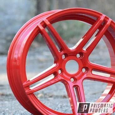 Astatic Red Solid Tone Polyester Powder Coating 1 LB High Gloss Finish for automotive metal wheel, high-gloss red rim outdoors.