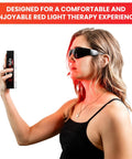Woman wearing Red Light Therapy Glasses With Eye Protection 600-900nm For Safe Use, holding a red light device.