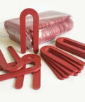 Red Plastic Horseshoe Shims, One Eighth Inch Thick By One And A Half Inch Wide By Three And A Half Inch Long, 100 Pack, displayed spread out