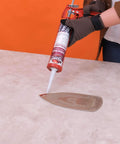 Person applying Red RTV Silicone Gasket Maker Sealant, Heavy Duty Automotive Grade, Oil Resistant And Heat Safe Up To 600F