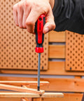 Hand using a screwdriver from 158 Piece Home Tool Kit With Plastic Storage Case to fix wooden furniture.