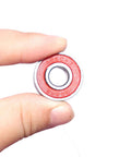 Quiet 608RS Skateboard Bearings Red 100 Pack Low Noise High Precision 8x22x7mm held in fingers, red shield visible