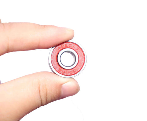 Quiet 608RS Skateboard Bearings Red 100 Pack Low Noise High Precision 8x22x7mm held in fingers, red shield visible