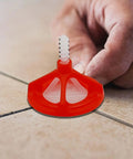 Close-up of One Eighth Inch Tile Leveling System With Spiral Spacers And Red Reusable Caps installed on tile floor