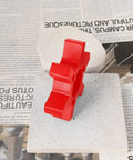 Red urethane jaw coupling insert L110 two pack for Lovejoy style L-jaw couplings on a stone tile with newspaper background.