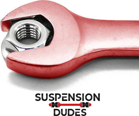 Four Piece Alignment Caster And Camber Kit For GM Trucks And SUVs Restores Factory Specs With Camber Adjustment Plus Or Minus One And A Half Degrees Reducing Tire Wear And Steering Pull Made In USA Anti Corrosion Protected Hardware Fits Tahoe Yukon with wrench close-up on logo.