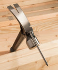 USA-made 19 oz rip claw framing hammer with milled face and shock reduction grip embedded in wood with magnetic nail starter.