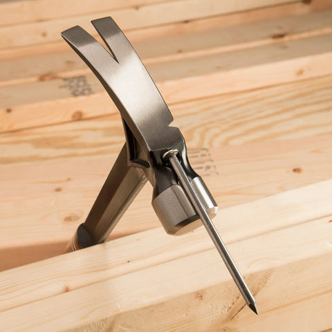 USA-made 19 oz rip claw framing hammer with milled face and shock reduction grip embedded in wood with magnetic nail starter.