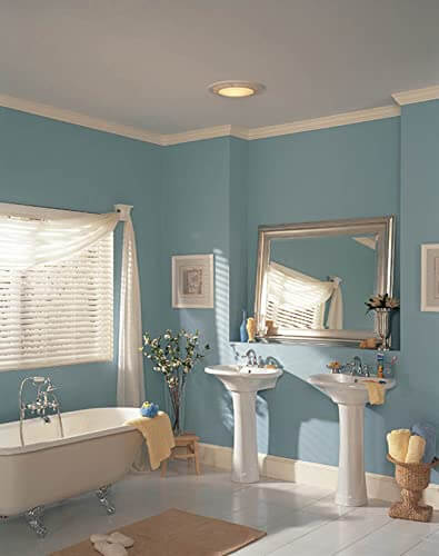 Round White Bath Exhaust Fan With Light And Glass Lens, 100 CFM, installed in a bathroom ceiling, showcasing modern look and easy install.