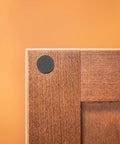 Assorted Round Self Stick Noise Dampening Foam Cabinet Bumper in use on wooden cabinet for quiet closures and surface protection.