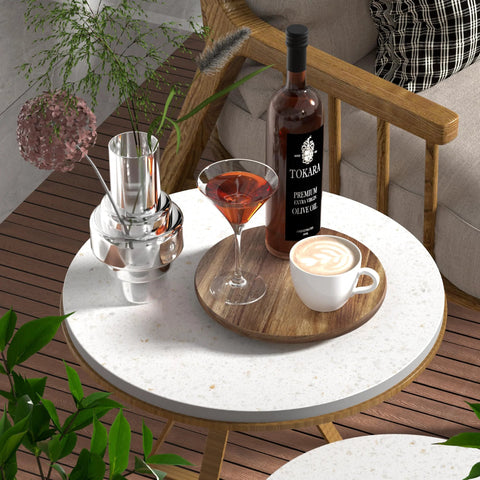 Round patio table with drinks, plant decor, and bottle on wood tray