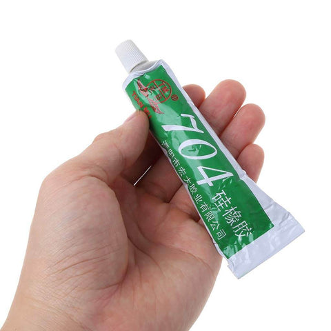 Heavy Duty RTV Silicone Adhesive 704 Rubber Glue 45g tube held in hand, suitable for electronics and machinery use, RoHS compliant.