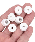12 Pack Rubber Bumper Feet 0.35 In High By 0.55 In Wide Round Pads With Stainless Steel Washer And Phillips Screws held in a hand