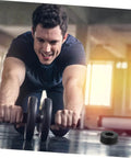 Person exercising with ab roller, rubber bumper visible on gym floor.