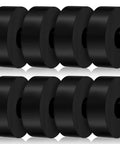 Eight piece set of thick rubber vibration isolation pads, 1.5 in OD, 0.5 in ID, arranged in two rows, black color, against a white background