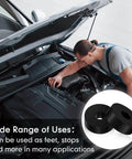 Mechanic working on car engine with eight piece set of thick rubber vibration isolation pads for washers and appliances shown