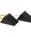 Mini Rubber Wheel Chock Set With 36 Inch Nylon Rope For ATVs, Riding Lawn Mowers, And Gas Powered Scooters, Durable 5 x 3 x 2.25 Inches Chocks That Are Rust And Chemical Proof For Secure Parking In Garage Or Storage. Two black rubber wheel chocks connected with yellow rope, side view.