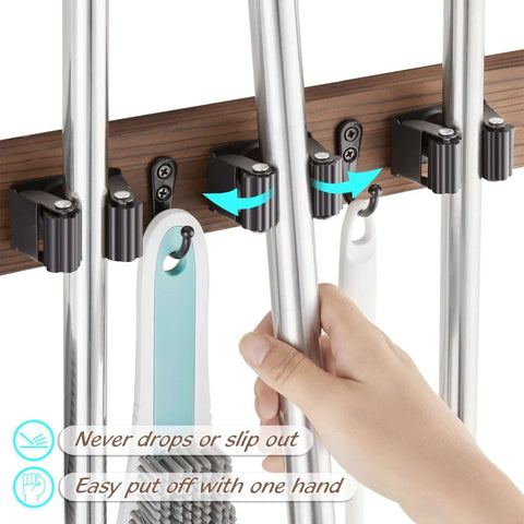 Hand using Rustic Wood Wall Mount Mop And Broom Organizer With 4 Slots And 4 Hooks For Closet Garage Laundry Kitchen Decor