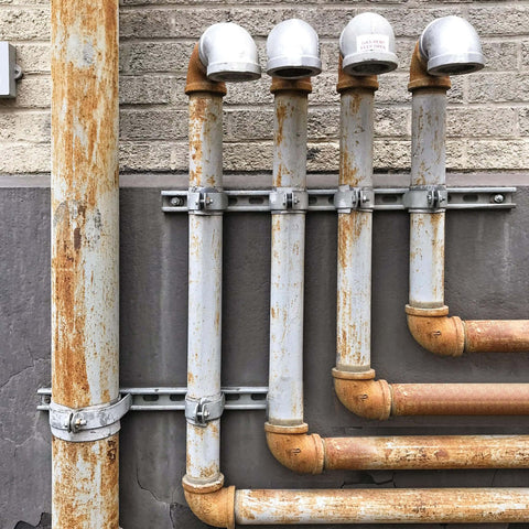 Ten-piece universal tube clamps deliver secure, corrosion-resistant support for Unistrut channels; 2 inch wall mount conduits, bolts and nuts included, galvanized steel for long lasting electrical and plumbing runs, supporting metal pipes on industrial wall.