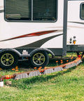 3 In 1 RV Sewer Hose Adapter And Drain Seal With RhinoExtreme Hose and Handle connected to RV, showing flexible universal fit in use.
