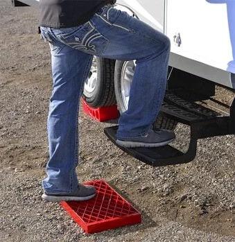 Heavy Duty RV Leveling Block Set 6 Pack With Free Step For Stable Parking with person using step next to RV tires.