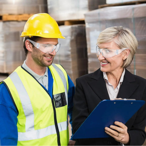 Workers wearing 48 Pack Safety Glasses Clear Protective Eyewear For Work Lab Lightweight Comfort, discussing in a warehouse.