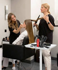 Women styling hair in salon with White Salon Tray Rolling Cart With Wheels Adjustable Height Service Tray for beauty tools