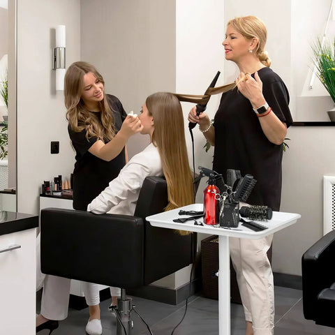 Women styling hair in salon with White Salon Tray Rolling Cart With Wheels Adjustable Height Service Tray for beauty tools