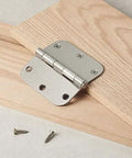 Interior Door Hinge Rounded 3.5 Inch By 3.5 Inch Satin Nickel Pack Of 18 shown with mounting screws on wood surface