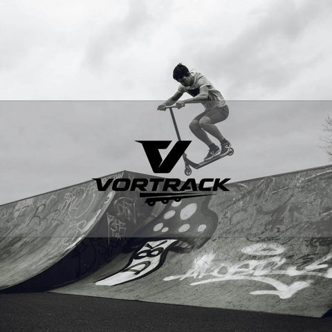 Skater performing a jump on half-pipe with Vortrack logo in foreground, monochrome image