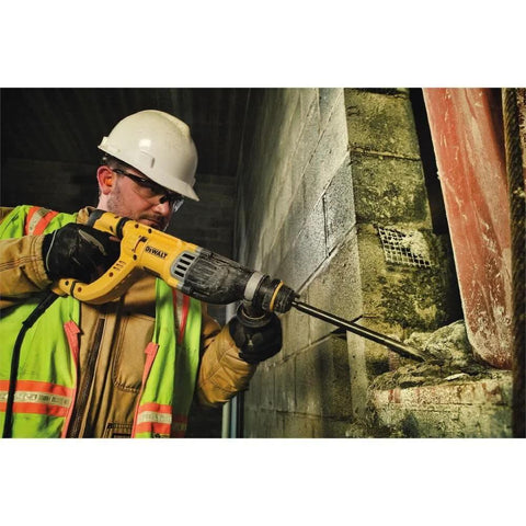 Person using lightweight corded SDS rotary hammer with Active Vibration Control to drill into masonry wall at work site