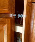 Self Adhesive Safety Latches For Baby And Adults securing a cabinet door, clear 9-inch strap, four flaps, installed with no tools.
