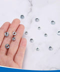 Person holding multiple zinc plated carbon steel nuts from the Heavy Duty Self Clinching Nuts Set For Metal Fastening M2, M2.5, M3, M4, M5 Zinc Plated Carbon Steel Rivet Nuts 300 Pieces For Construction And Diy Projects By Uxcell.