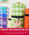Hand securing fabric roll with One-Wrap Double-Sided Self Gripping Hook And Loop Tape Roll For Cable Management on a shelf.