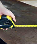 Self locking tape measure with belt clip offers precise 33 feet of measurement with MID accuracy, shown in hand on table.