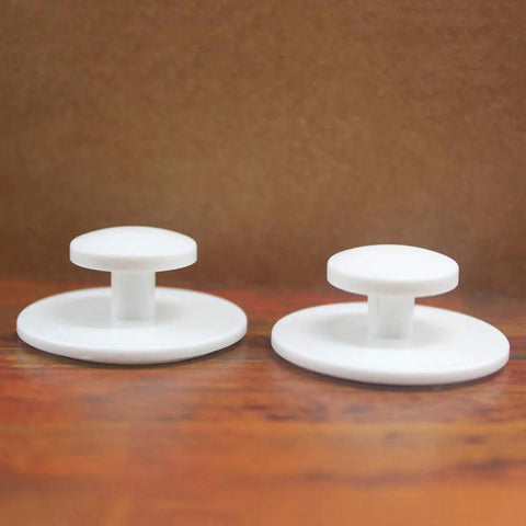 Two white knobs from the Ten Piece Pack Self Stick Drawer Knobs For Cabinets And Doors No Glue Needed Peel And Stick Installation Easy To Install Mini Handles.