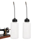 Two Pack 120ml Sewing Machine Oil Can Set With Precision Long Nozzle Lubricant Dispenser next to sewing machine