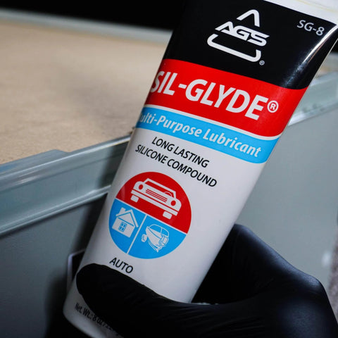 SIL-Glyde Multi-Purpose All-Weather Lubricating Compound for All Surfaces - 8 oz Tube image, held in a gloved hand