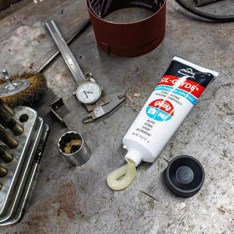 SIL-Glyde Multi-Purpose All-Weather Lubricating Compound for All Surfaces - 8 oz Tube on workshop table.