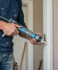 Person applying Premium 100 Percent Silicone Caulk For Windows And Doors White Weatherproof RTV Sealant For Indoor And Outdoor Use Easy Apply No Mess Caulking Adhesive 9.5 Oz Cartridge 12 Pack on door frame