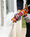 Person applying All Purpose Silicone Caulk Clear Sealant For Bathrooms And Showers Waterproof RTV Silicone Sealant Tub And Shower Grade 9.5 Fl Oz Cartridge 12 Pack For Long Lasting Bond on a window ledge using a caulk gun.