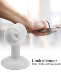 Two-piece silicone door handle silencers that absorb impact and reduce noise, shown installed on a door handle to protect walls from scuffs.