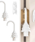 Christmas Tree Hanging Silicone Door Pinch Guard And Anti Door Slam Stopper Set For Baby Proofing Homes Keeps Doors Open And Fingers Safe With Hidden Hinge Mount Kid Safe And Easy To Install 2 Pack White installed on a door hinge, showing tree shape and hidden hinge mount design.