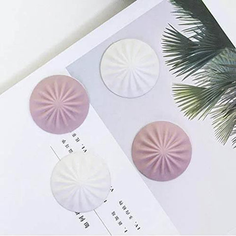 Silent anti collision door stopper cushions door knocks with silicone rubber in white and pink colors on a book page
