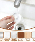 Person holding a Clear Door Stopper Wall Protector For Doors, 2 Inch Round Silicone Rubber Guard, rinsing under tap water, with material icons below.