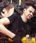 Man using power tool wearing Orange Banded Silicone Ear Plugs for Shooting Range and Noise Reduction with Lightweight Plastic Banding
